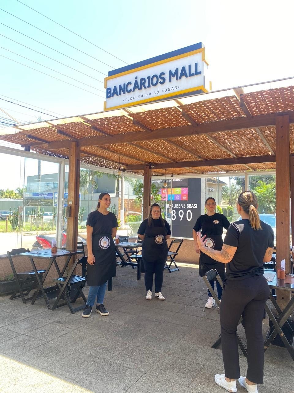 Daniela orientando equipe de atendimento em área externa de restaurante